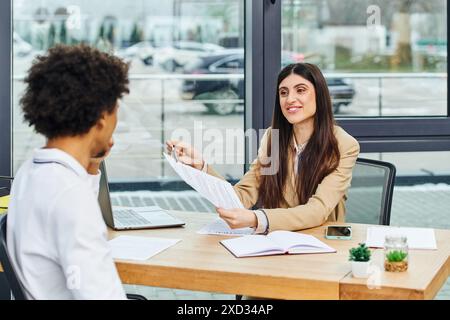 Uomo e donna si impegnano in una conversazione alla scrivania durante il colloquio di lavoro. Foto Stock