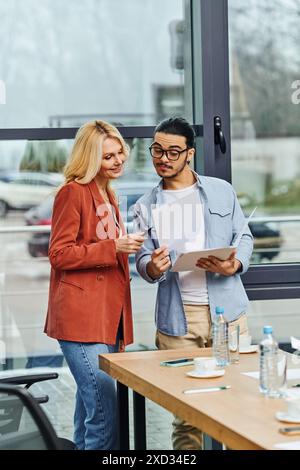 Due professionisti impegnati in una riunione in una moderna sala conferenze. Foto Stock