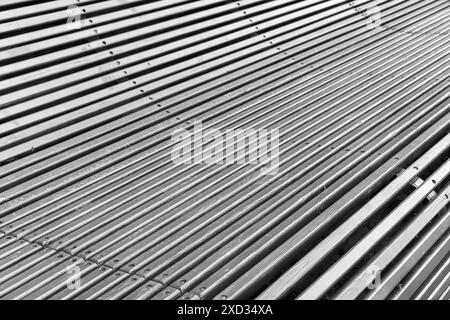 Costruzione di banchi da parcheggio in legno grigio piegato. Sfondo architettonico astratto, foto in bianco e nero Foto Stock