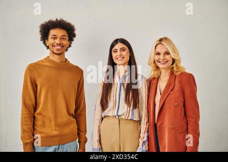 Tre persone attraenti posano di fronte a uno sfondo bianco. Foto Stock