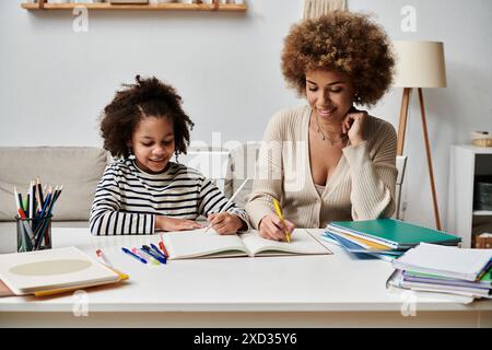 Una madre afroamericana e sua figlia siedono a un tavolo, impegnati a fare i compiti insieme, condividendo un momento speciale. Foto Stock
