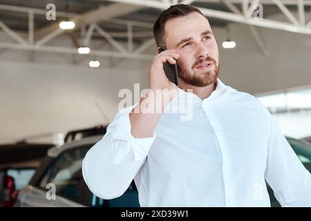 Telefonata, colloquio o venditore presso la concessionaria per il veicolo, la comunicazione finanziaria o il networking. Commerciante, agente o venditore nello showroom che parla per Foto Stock