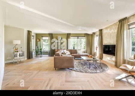 Elegante soggiorno con mobili moderni e grandi finestre affacciate sul verde. Foto Stock