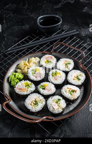 Gimbap Kimbap ripieno di verdure, uova, acciughe e granchio, rotolo di riso coreano. Sfondo nero. Vista dall'alto. Foto Stock