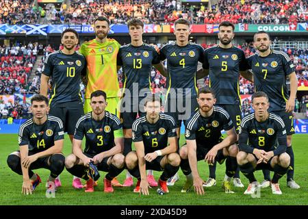 Giocatori di Scozia con Ché Adams (10) di Scozia, portiere Angus Gunn (1) di Scozia, Jack Hendry (13) di Scozia, Scott McTominay (4) di Scozia, Grant Hanley (5) di Scozia, John McGinn (7) di Scozia, Billy Gilmour (14) di Scozia, Andrew Robertson (3) di Scozia, Kieran Tierney (6) di Scozia, Anthony Ralston (2) della Scozia e Callum McGregor (8) della Scozia si presentano per una foto della squadra durante una partita di calcio tra le squadre nazionali di Scozia e Svizzera il secondo giorno della partita nel gruppo A nella fase a gironi del torneo UEFA Euro 2024, mercoledì 19 giugno 2024 a Colonia Foto Stock