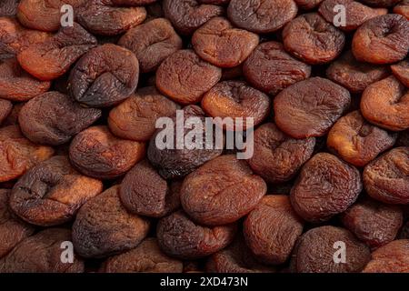 Albicocche essiccate naturalmente di colore arancione. Albicocche essiccate al sole disposte simmetricamente. Albicocca secca. Gustose albicocche secche come sfondo, vista dall'alto. H Foto Stock