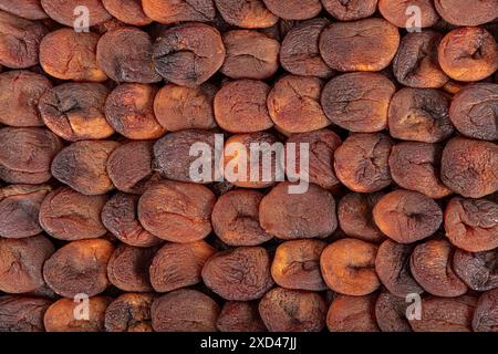 Albicocche essiccate naturalmente di colore arancione. Albicocche essiccate al sole disposte simmetricamente. Albicocca secca. Gustose albicocche secche come sfondo, vista dall'alto. H Foto Stock