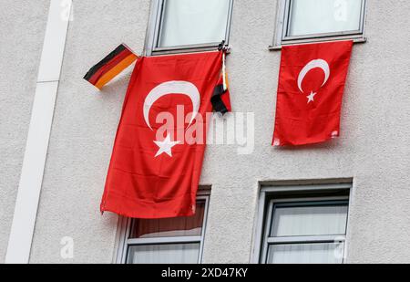 Due bandiere turche e una piccola bandiera tedesca appesa alle finestre di una casa durante il Campionato europeo di calcio, Berlino, 19 giugno 2024 Foto Stock