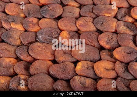 Albicocche essiccate naturalmente di colore arancione. Albicocche essiccate al sole disposte simmetricamente. Albicocca secca. Gustose albicocche secche come sfondo, vista dall'alto. H Foto Stock