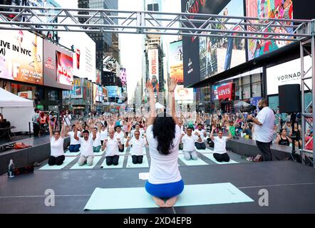 New York, Stati Uniti. 20 giugno 2024. La gente partecipa ad una lezione di yoga in celebrazione del solstizio d'estate ad un 22° evento annuale di yoga all'aperto tutto il giorno a Times Square a New York City giovedì 20 giugno 2024. Foto di John Angelillo/UPI credito: UPI/Alamy Live News Foto Stock