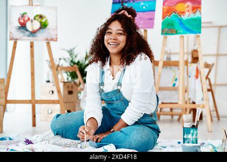 Arte, pittura e donna che ride in studio, acrilico e apprendista per progetto creativo. Donna, pittrice e artista per l'artigianato a pavimento Foto Stock