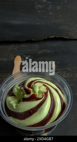 La foto è una foto di gelato al gusto di avocado in una tazza con sfondo nero Foto Stock