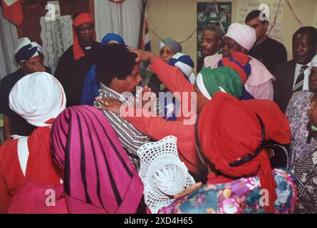 La chiesa battista spirituale del monte Sion, un membro anziano della chiesa, mette le mani sulla testa e sulla spalla di un supplicante, che sta pregando. Va in trance. Kensal Green, Londra, Inghilterra 1990. 1990 UK HOMER SYKES Foto Stock