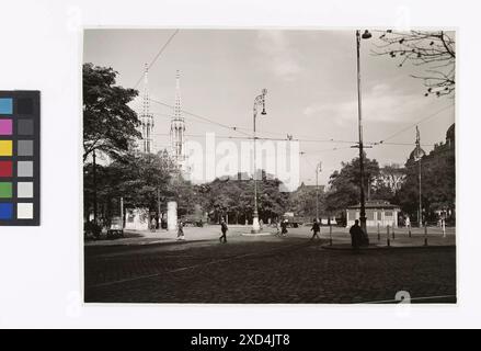 bez.: 'Hermann Göringplatz.'. 1., Schottenring / Universitätsstraße / Währinger Straße / Schottengasse (Schottenkreuzung) - Allgemein - Blick von Höhe Universität Richtung Währinger Straße und Votivkirche Martin Gerlach jun. (1879-1944), Museo del fotografo di Vienna, Timotheus Tomicek, chiesa (esterno), camion, furgone, poster, poster, illuminazione stradale, con persone, uniformi (militari), stazione, riparo (ferrovia, tram), rotaie, quadrato, luogo, circo, ecc., alberi, Schottenring 1940 Foto Stock