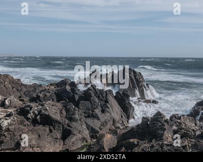 Guarda da vicino come si infrangono le onde dell'oceano Atlantico sulla grande pietra rocciosa della splendida spiaggia vulcanica del portogallo Foto Stock