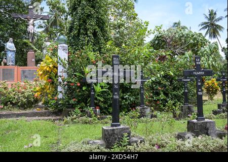 PAPUA NUOVA GUINEA, Madang, Alexishafen SVD Catholic Mission St. Michael, fondata nel 1905 durante il periodo coloniale tedesco, cimitero di missione con tombe di missionari tedeschi SVD e memoriale per le vittime tedesche della seconda guerra mondiale nel pacifico, Yorishime Maru e Akikaze Ship Catastrophe / PAPUA NEUGUINEA, Madang, Alexishafen, katholische Steyler Mission Sankt Michael, Die 1905 während der deutschen Kolonialzeit gegründet wurde, Friedhof mit Gräbern von deutschen Steyler Missionaren und Gedenkstein für deutsche Opfer des zweiten Weltkriegs im Pazifik Foto Stock