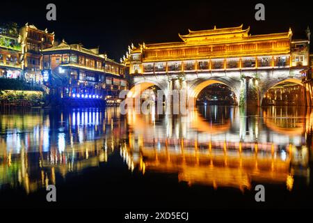 Vista notturna colorata del Ponte di Hong (Ponte dell'Arcobaleno) sul fiume Tuojiang (fiume tuo Jiang) nella città antica di Phoenix (Contea di Fenghuang), Cina. Foto Stock