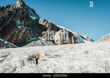 Gruppo di escursionisti che fanno trekking sulle montagne dell'Himalaya attraverso il ghiacciaio e il passo Cho la. A Gokyo Ri. Guida maschile nepalese che conduce il cliente turistico a Sagarmat Foto Stock