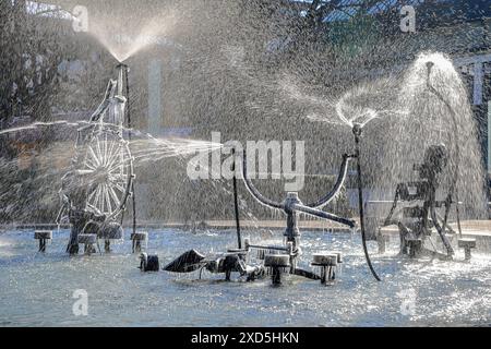 Basilea, Svizzera - 07 febbraio 2023: L'artistica Fontana di Tinguely nel centro della città con parti parzialmente congelate e spruzzi in retroluce con wi freddo Foto Stock