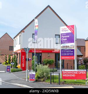 Taylor Wimpey Homes firma con le informazioni di vendita all'esterno dell'ufficio vendite e mostra case a Parsons Chain New Housing Development, Stourport-on-Severn, Worcs, Regno Unito. Foto Stock