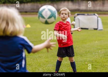 Kinder spielen mit einem Ball auf dem Fussballplatz, Bonn, 19.06.2024. Bonn Deutschland *** bambini che giocano con una palla sul campo di calcio, Bonn, 19 Foto Stock