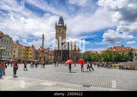 Piazza della città Vecchia di Praga, piena di turisti, con il Municipio della città Vecchia, la colonna Mariana e il Memoriale di Jan Hus sotto un vivace cielo blu. Foto Stock