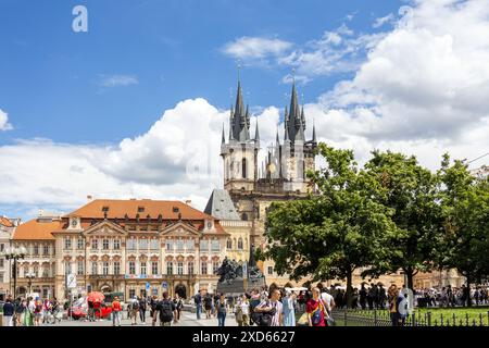 Piazza della città Vecchia di Praga, piena di turisti, con la Chiesa di nostra Signora prima di Týn e il Memoriale di Jan Hus sotto un cielo blu brillante. Foto Stock