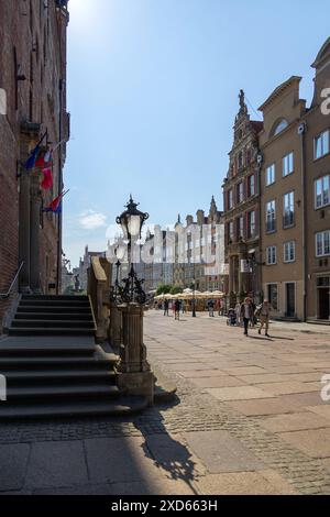 Un momento tranquillo in via Długa a Danzica, con storici lampioni, edifici colorati e un cielo azzurro. Foto Stock