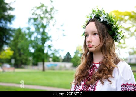 Donna Ucraina che cammina nella foresta di abeti, montagne dei Carpazi natura. Ragazza in abito vyshyvanka ricamato tradizionale, corona rossa, gioielli antichi. Ucraina, libertà, costume etnico nazionale Foto Stock