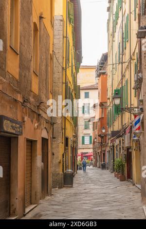 Pisa, Italia; 18 giugno 2024 - Una persona cammina per le vie secondarie di Pisa, Italia Foto Stock