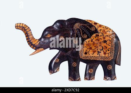 La decorazione delle pareti e' fatta di legno, a forma di elefante, ed e' dipinta con motivi batik, isolata su sfondo bianco Foto Stock