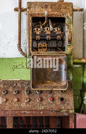 Dettagli in metallo arrugginito con scatola elettrica Grunge in una vecchia fabbrica di trapani abbandonata Foto Stock