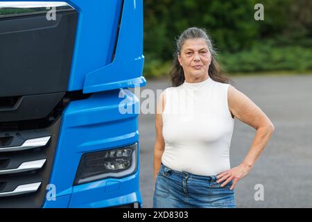 Attraente camionista anziano in piedi accanto al suo veicolo Foto Stock