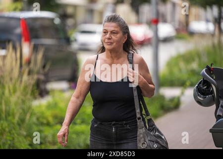 Una donna anziana che fa shopping in città Foto Stock