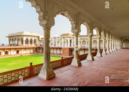 Splendida vista del lungo passaggio del forte di Agra, India. Il cortile panoramico è visibile attraverso archi scolpiti. Incredibile architettura moghul. Foto Stock