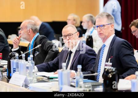 Potsdam, Germania. 21 giugno 2024. Michael Stübgen (CDU, centro), ministro dell'interno del Brandeburgo, apre la sessione di lavoro l'ultimo giorno della Conferenza di primavera dei ministri dell'interno e dei senatori dell'interno presso il Dorint Hotel, accanto a Lars von Dewitz (a destra), consigliere ministeriale presso l'Ufficio del Consiglio federale del Comitato per gli affari interni, e Markus Grünewald (a sinistra), Segretario di Stato presso il Ministero degli interni e degli affari comunali dello Stato di Brandeburgo. Crediti: Christoph Soeder/dpa/Alamy Live News Foto Stock