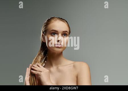 Bella donna con capelli lunghi che applica dolcemente prodotti per la cura dei capelli. Foto Stock