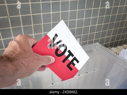 Posizionamento manuale del voto nella casella con bandiera polacca Foto Stock