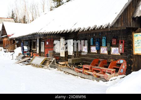 Cottage siberiano in legno con slitte tradizionali in inverno Foto Stock