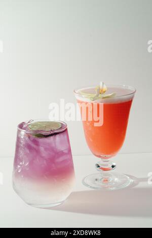 Due cocktail vivaci, uno viola e uno arancione. Foto Stock