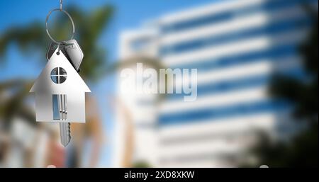 Immagine della chiave con il portachiavi della casa su un paesaggio urbano sfocato Foto Stock