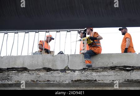 Non esclusiva: KIEV, UCRAINA - 20 GIUGNO 2024 - i lavoratori riparano i frammenti della sezione pedonale del cavalcavia Povitroflotskyi che è crollato Foto Stock