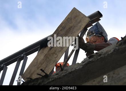 Non esclusiva: KIEV, UCRAINA - 20 GIUGNO 2024 - i lavoratori riparano i frammenti della sezione pedonale del cavalcavia Povitroflotskyi che è crollato Foto Stock