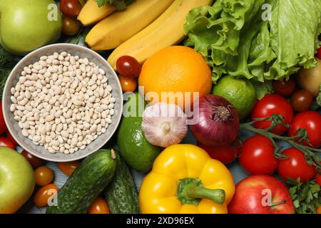 Fonte di proteine per i vegetariani. Diverse verdure fresche, frutta e cereali come sfondo, vista dall'alto Foto Stock
