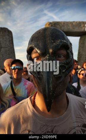 Salisbury, Inghilterra, Regno Unito. 20 giugno 2024. Uno di quelli che celebrano il solstizio d'estate indossa una maschera con becchi elaborati all'interno delle pietre di Stonehenge. Stonehenge fu costruita dai primi britannici circa 4000 anni fa per allinearsi al sole sui solstizi. Il solstizio d'estate segna la fine della primavera e l'inizio dell'estate ed è il giorno più lungo e la notte più breve dell'emisfero settentrionale. L'evento è celebrato da migliaia di pagani in tutto il mondo con canti e balli. (Credit Image: © Martin Pope/ZUMA Press Wire) SOLO PER USO EDITORIALE! Non per USO commerciale! Foto Stock