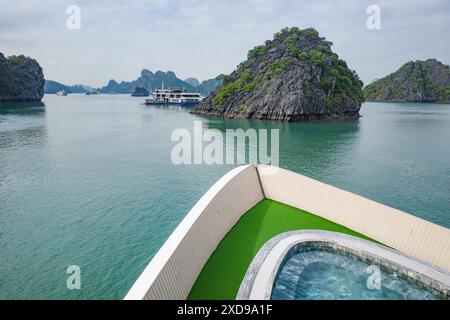 Baia di ha Long, Vietnam - 30 gennaio 2024: Barche da crociera a vela sulla baia di ha Long, patrimonio dell'umanità dell'UNESCO nel Mar Cinese meridionale Foto Stock