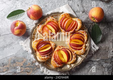 Dessert estivo torta al cuore di pesca con frutta matura e marmellata da vicino in un piatto sul tavolo. Vista dall'alto orizzontale Foto Stock