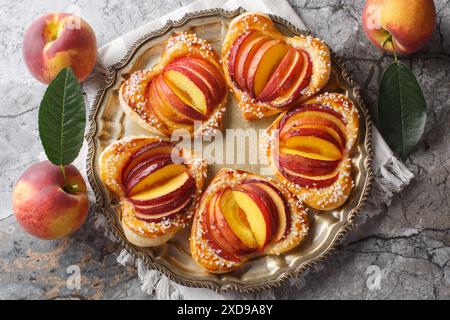 Deliziosa torta di cuore alla pesca con frutta fresca e marmellata da vicino in un piatto sul tavolo. Vista dall'alto orizzontale Foto Stock