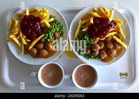 IKEA Food - gastronomia. Zwei Portionen Köttbullar mit Pommes und Erbsen, dazu zwei Tassen Kakao bzw heisse Schokolade. Köttbullar sind traditionelle schwedische Fleischbällchen, die gebraten, typischerweise mit PreiselbeerÂkompott oder -marmelade, SahneÂsauce und Salzkartoffeln oder Kartoffelpüree zubereitet werden. In deutscher Übersetzung entspricht kött-bullar sinngemäss dem Fleisch-Brötchen **** Ikea Food Gastronomie due porzioni di köttbullar con patatine e piselli, servite con due tazze di cacao o cioccolata calda Köttbullar sono polpette tradizionali svedesi fritte, in genere con l'imbrunire Foto Stock