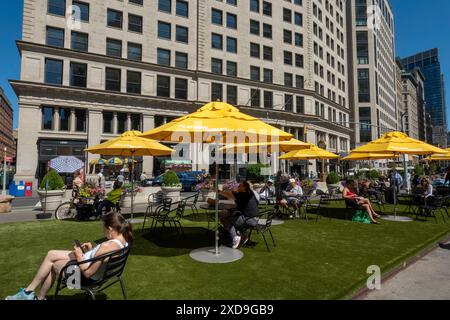 L'area pubblica con posti a sedere a Fifth Avenue e 23rd St. Presenta ombrelli gialli luminosi per ombra, 2024, New York City, Nomad, Stati Uniti Foto Stock